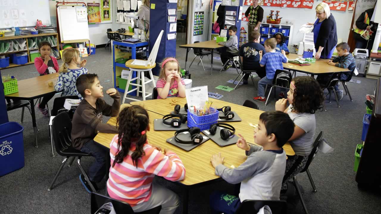 In this March 10, 2015 photo, teacher Allison Williams works with her kindergarten students in a lassroom at Des Moines Elementary School in Des Moines, Wash.