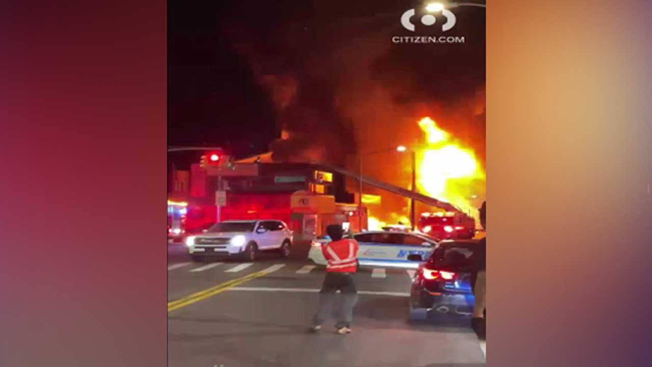 Heavy flames erupt from auto body shop in Brooklyn