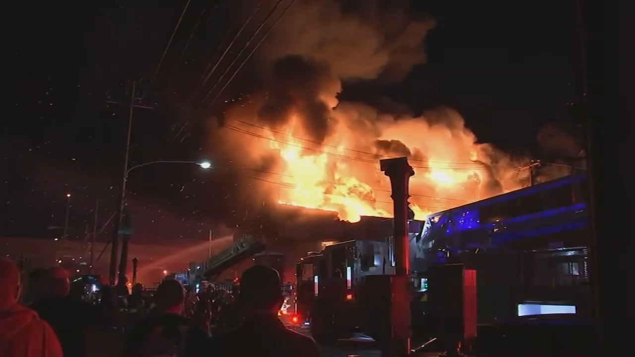 Massive warehouse fire under control, crews save neighborhood bar