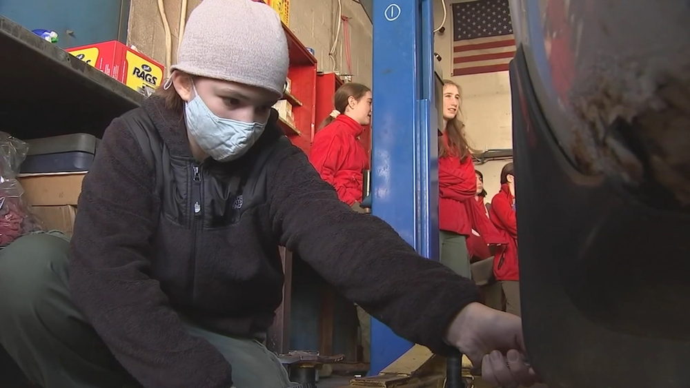 Female mechanic teaches girl scout troop basic car maintenance