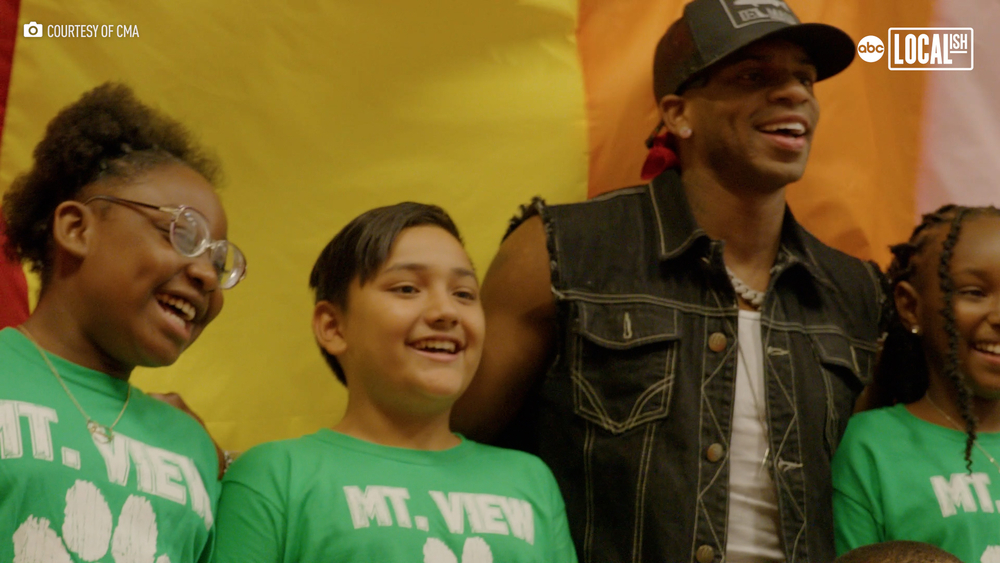 School kids perform with country music legend
