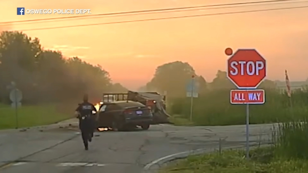 Police run toward burning car to rescue 2 after Oswego crash | Video