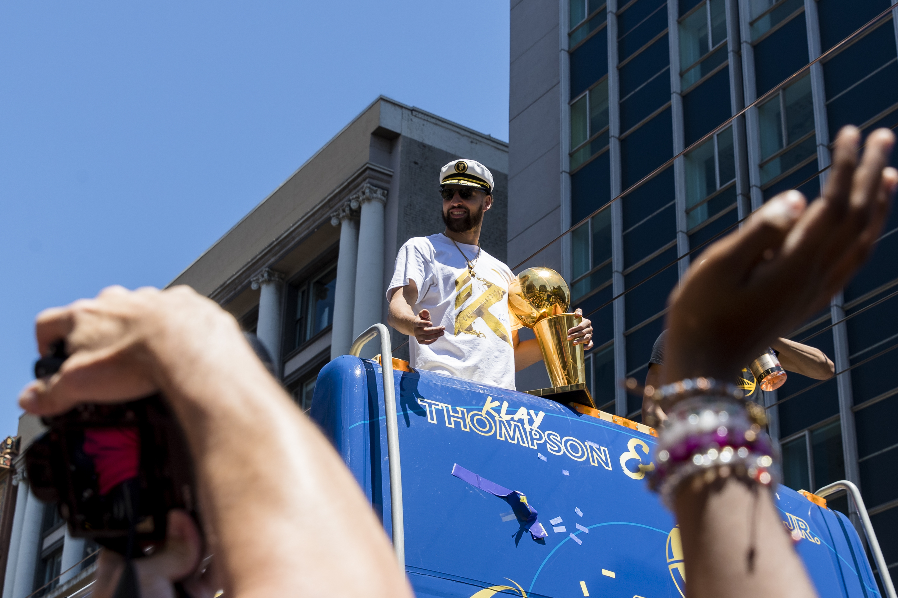 Golden State Warriors' Klay Thompson gestures to the crowd as he holds the Larry O'Brien trophy during the NBA Championship parade in San Francisco, Monday, June 20, 2022.