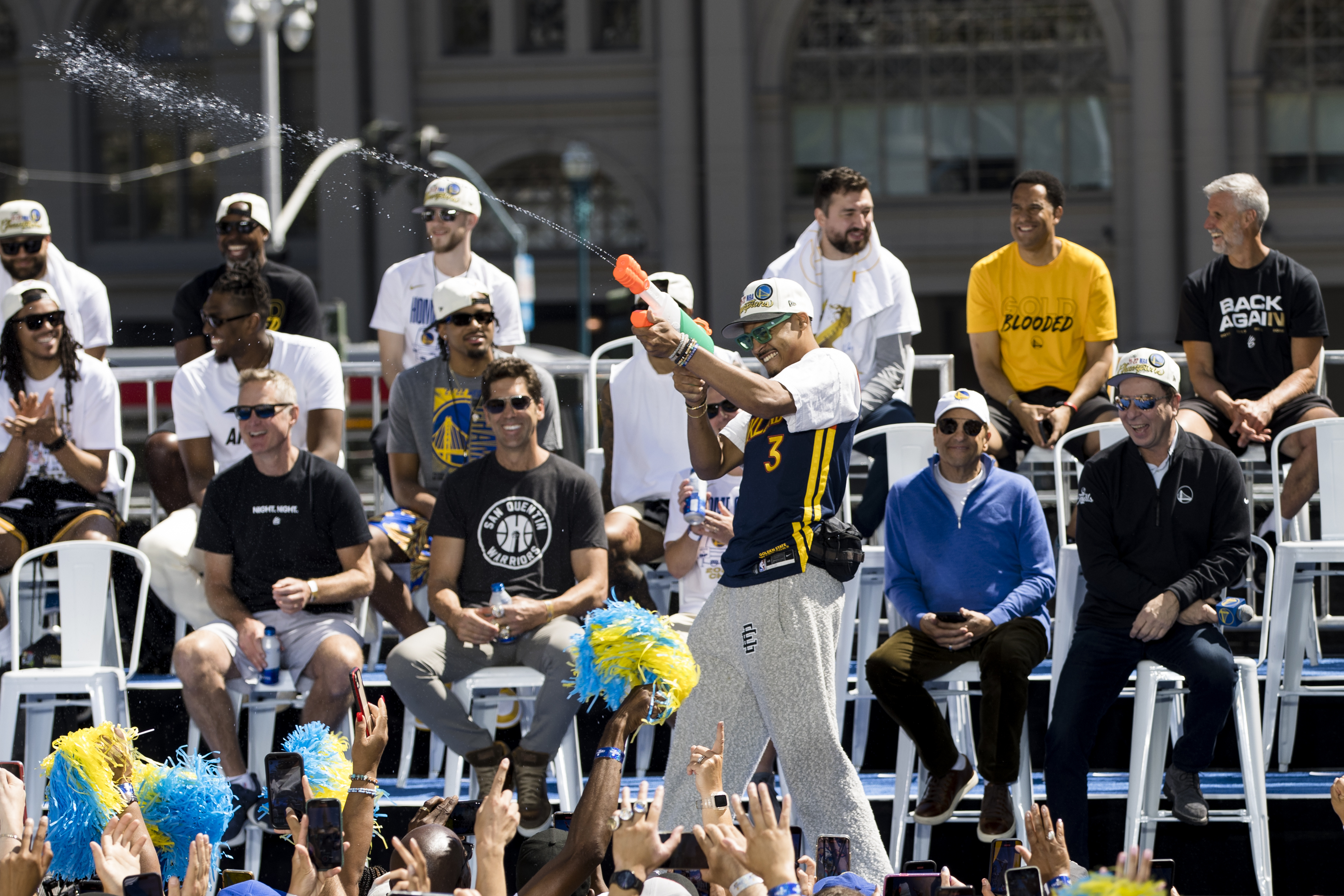 Golden State Warriors' Jordan Poole (3) squirts water on the crowd before the NBA Championship parade in San Francisco, Monday, June 20, 2022, in San Francisco.