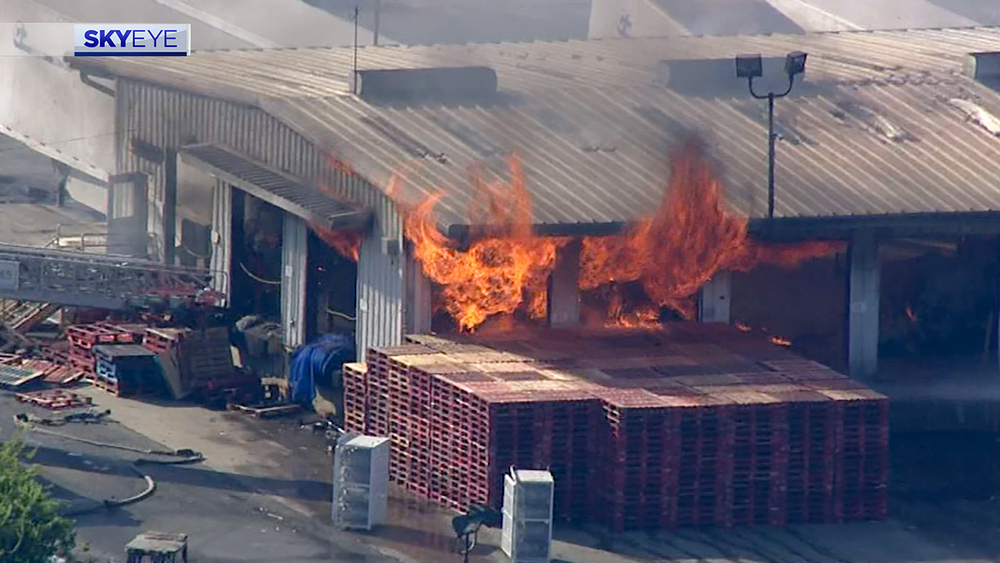 Flames shoot out from warehouse with multiple big rigs in NE Houston