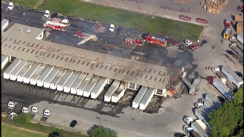 Flames shoot out from warehouse with multiple big rigs in NE Houston