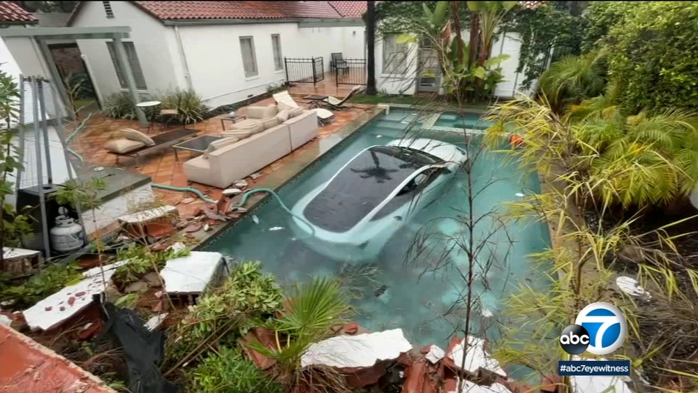 Tesla driver slams through wall, lands in pool; 3 people rescued