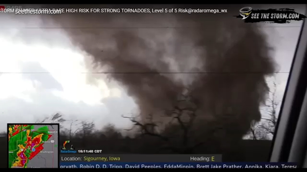 Tornado swirls debris across road in front of storm chasers in Harper, Iowa