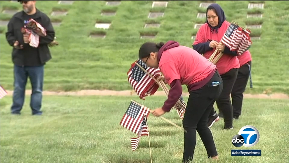 Hundreds place flags on gravesites of vets at Riverside cemetery