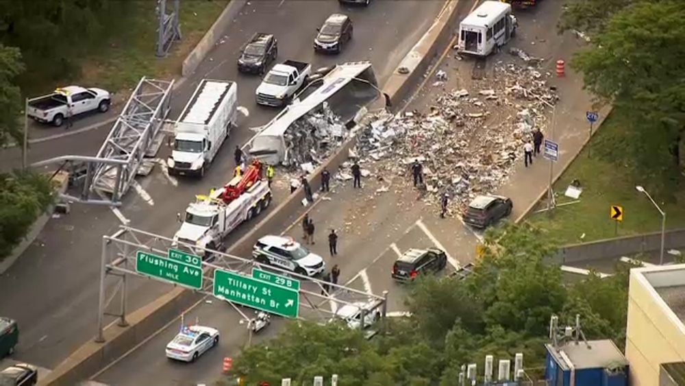 4 injured in crash as overturned truck dumps load of trash on BQE