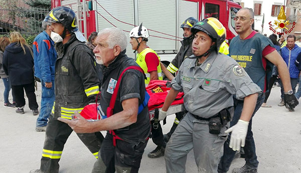 Rescuers carry a victim on a stretcher in the town of Amatrice, central Italy, Wednesday, Aug. 24, 2016 following an earthquake.