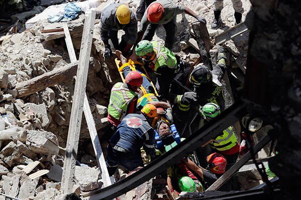 A man is rescued from the rubble of a building after an earthquake, in Accumoli, central Italy, Wednesday, Aug. 24, 2016