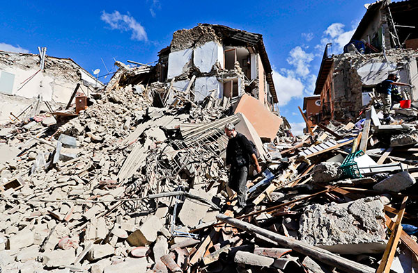 A man walks amid rubbles after an earthquake struck in Amatrice Italy, Wednesday, Aug. 24, 2016.