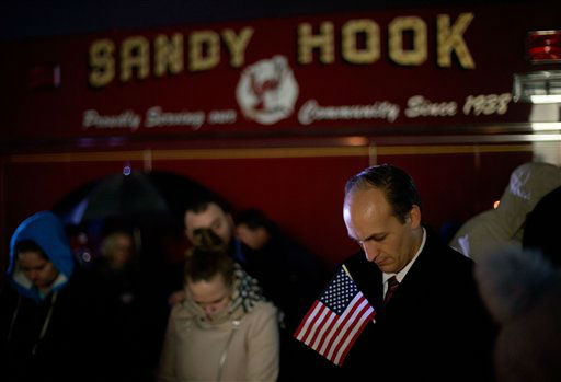 Mourners listen to a memorial service over a loudspeaker outside Newtown High School for the victims of the Sandy Hook Elementary School shooting, Sunday, Dec. 16, 2012, in Newtown, Conn. (AP Photo/David Goldman)