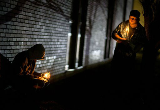Mourners listen to a memorial service over a loudspeaker outside Newtown High School for the victims of the Sandy Hook Elementary School shooting, Sunday, Dec. 16, 2012, in Newtown, Conn. (AP Photo/David Goldman)