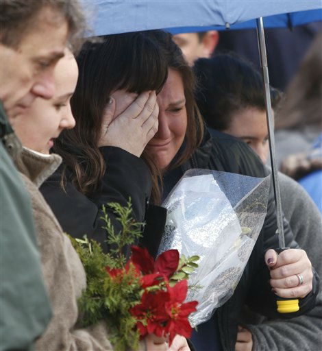 Mourners pay their respects at a memorial for shooting victims near Sandy Hook Elementary School, Sunday, Dec. 16, 2012 in Newtown, Conn. A gunman walked into Sandy Hook Elementary School in Newtown Friday and opened fire, killing 26 people, including 20 children. (AP Photo/Jason DeCrow)