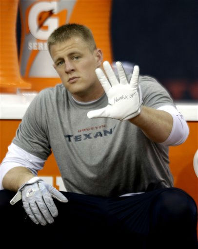 Houston Texans defensive end J.J. Watt wears Newton, Ct on his glove to honor 20 children and 6 adults killed Friday in a shooting rampage at Sandy Hook Elementary School in Newtown, Conn. as he warms up before an NFL football game against the Indianapolis Colts Sunday, Dec. 16, 2012, in Houston. (AP Photo/David J. Phillip)