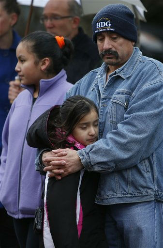 Mourners pay their respects at a memorial for shooting victims near Sandy Hook Elementary School, Sunday, Dec. 16, 2012 in Newtown, Conn. A gunman walked into Sandy Hook Elementary School in Newtown Friday and opened fire, killing 26 people, including 20 children. (AP Photo/Jason DeCrow)