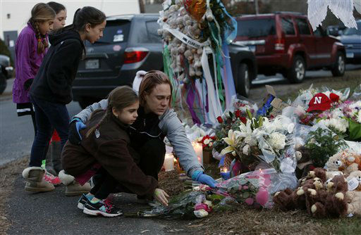 Mourners pay their respects at a memorial for shooting victims near Sandy Hook Elementary School, Saturday, Dec. 15, 2012 in Newtown, Conn. A gunman walked into Sandy Hook Elementary School in Newtown Friday and opened fire, killing 26 people, including 20 children. (AP Photo/Jason DeCrow)