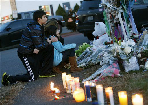 Mourners pay their respects at a memorial for shooting victims near Sandy Hook Elementary School, Saturday, Dec. 15, 2012 in Newtown, Conn. A gunman walked into Sandy Hook Elementary School in Newtown Friday and opened fire, killing 26 people, including 20 children. (AP Photo/Jason DeCrow)