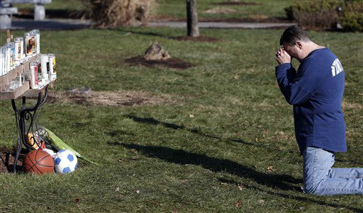 A man weeps while praying in front of a memorial for shooting victims outside Saint Rose of Lima Roman Catholic Church, Saturday, Dec. 15, 2012 in Newtown, Conn. The massacre of 26 children and adults at Sandy Hook Elementary school elicited horror and soul-searching around the world even as it raised more basic questions about why the gunman, 20-year-old Adam Lanza, would have been driven to such a crime and how he chose his victims. (AP Photo/Jason DeCrow)
