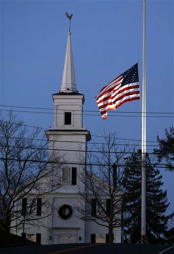 An American flag flies at half-staff as dawn breaks, Saturday, Dec. 15, 2012 in Newtown, Conn. A gunman walked into Sandy Hook Elementary School in Newtown Friday and opened fire, killing 26 people, including 20 children. (AP Photo/Jason DeCrow)