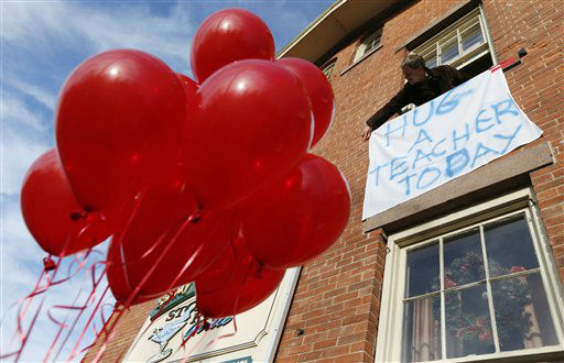 Gary Seri, general manager at the Stone River Grille, hangs a message written on a table cloth in honor of the teachers who died along with students a day earlier when a gunman open fire at Sandy Hook Elementary School, Saturday, Dec. 15, 2012, in the Sandy Hook village of Newtown, Conn. Seri, who put up red balloons that were not used when a sweet 16 party was canceled the night before in light of the massacre, said the teachers were scheduled to have their holiday party at his restaurant. The massacre of 26 children and adults at Sandy Hook Elementary school elicited horror and soul-searching around the world even as it raised more basic questions about why the gunman, 20-year-old Adam Lanza, would have been driven to such a crime and how he chose his victims. (AP Photo/Julio Cortez)