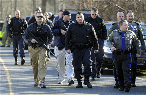 Law enforcement canvass the area following a shooting at the Sandy Hook Elementary School in Newtown, Conn. where authorities say a gunman opened fire, leaving 27 people dead, including 20 children, Friday, Dec. 14, 2012. (AP Photo/Jessica Hill)