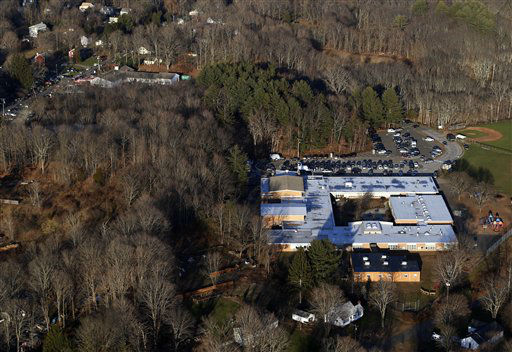 This aerial photo shows Sandy Hook Elementary School in Newtown, Conn., right, where authorities say a gunman opened fire inside the school in a shooting that left 27 people dead, including 18 children, Friday, Dec. 14, 2012. (AP Photo/Julio Cortez)