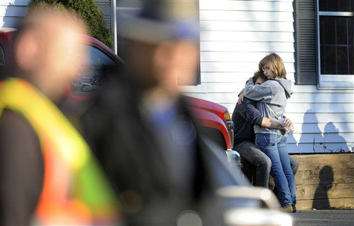 People embrace at a firehouse staging area for family around near the scene of a shooting at the Sandy Hook Elementary School in Newtown, Conn., about 60 miles (96 kilometers) northeast of New York City, Friday, Dec. 14, 2012. An official with knowledge of Friday's shooting said 27 people were dead, including 18 children. (AP Photo/Jessica Hill)