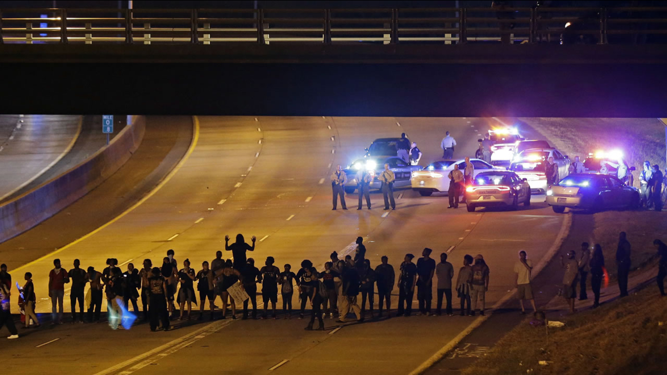 Police confront protesters blocking I-277 during demonstrations following Tuesday's police shooting of Keith Lamont Scott in Charlotte, N.C., Thursday, Sept. 22, 2016.