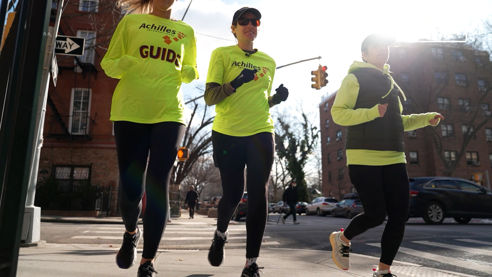 Legally blind runner, guides at her side, reaches for NYC Half finish