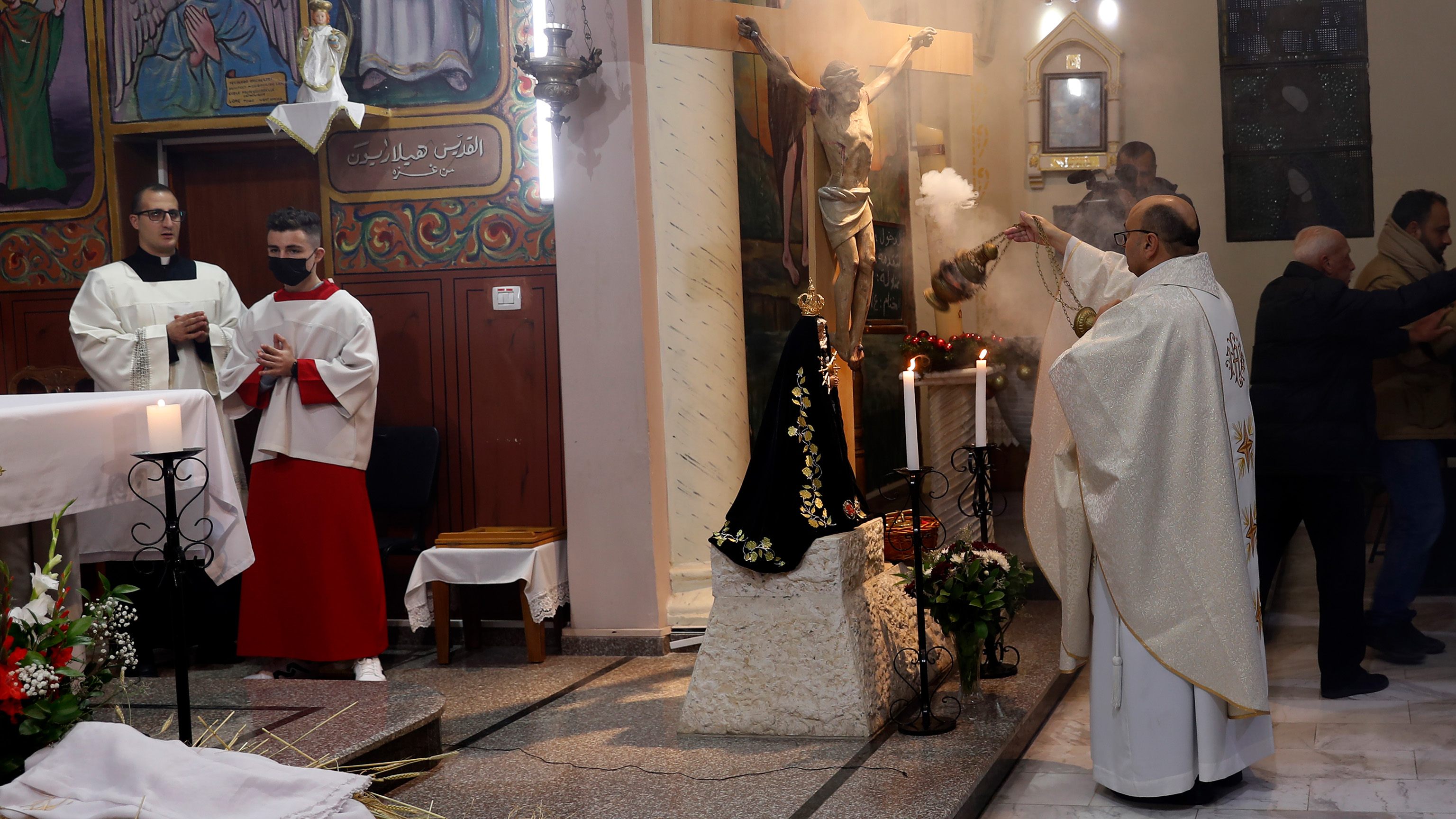 FILE -Fr. Gabriel Romanelli, Latin parish priest of Gaza Strip, left, prays during the midnight Christmas Eve mass at Deir Al Latin Holy Family Catholic Church in Gaza City, Dec. 24, 2021.