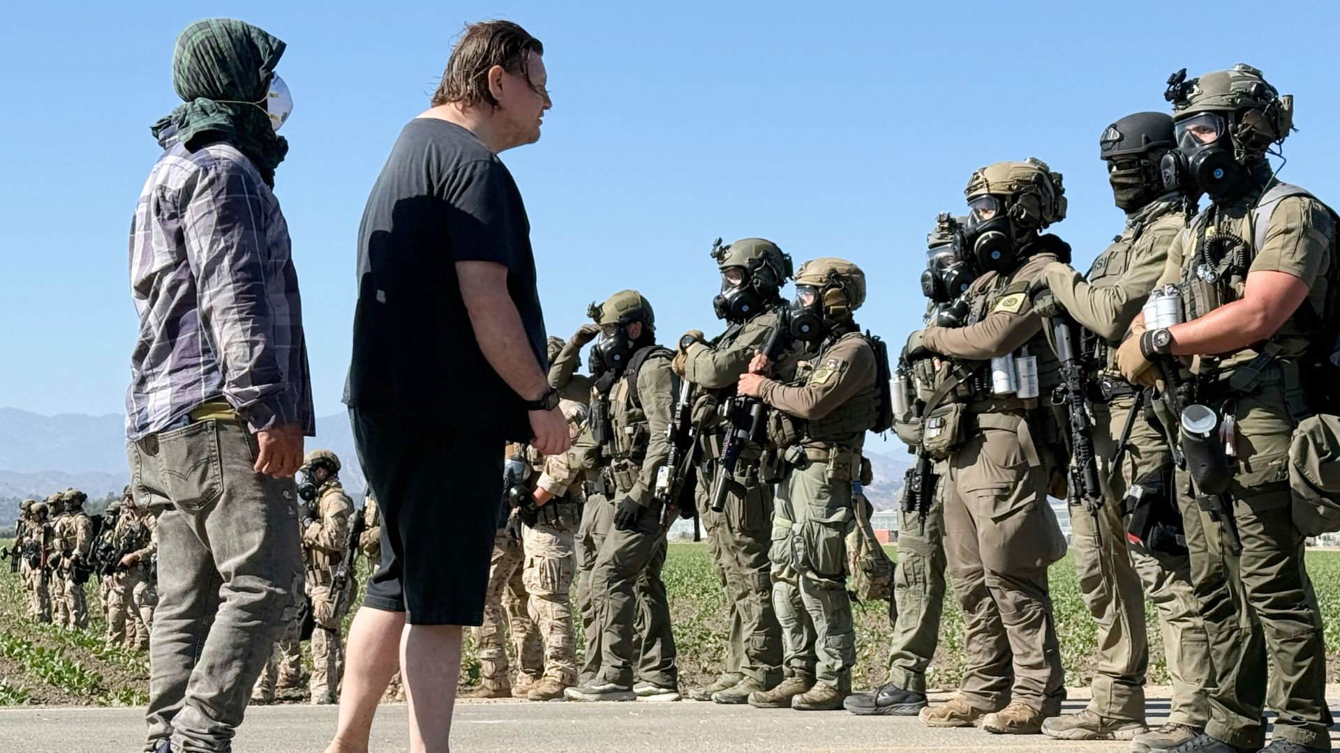 Demonstrators confront federal agents blocking a road during an immigration raid in Camarillo, Calif.