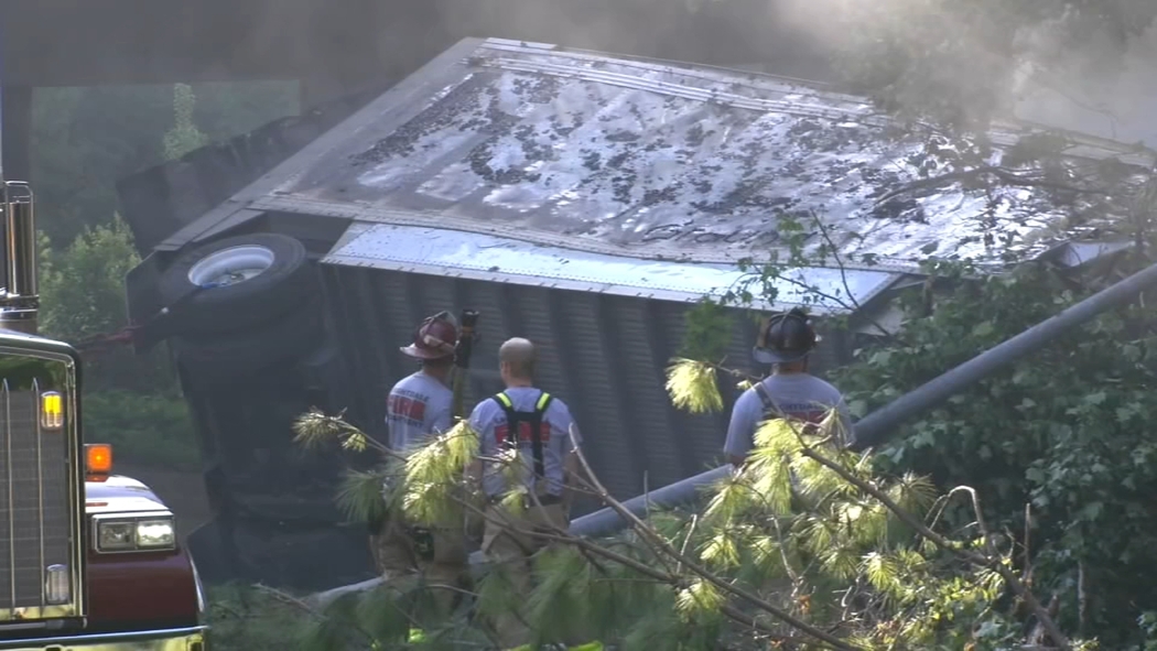 Burned FedEx tractor-trailer under the I-540 bridge near Knightdale NC, smoke and fire response visible. FedEx Truck Fire Knightdale NC