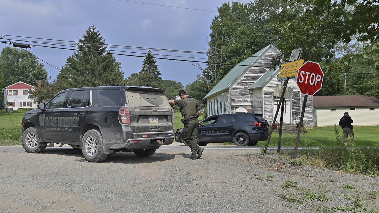 Officers block the street leading to where two Pennsylvania state troopers were ambushed and shot Thursday, Aug. 7, 2025, near the village of Thompson in Susquehanna County, Pa.