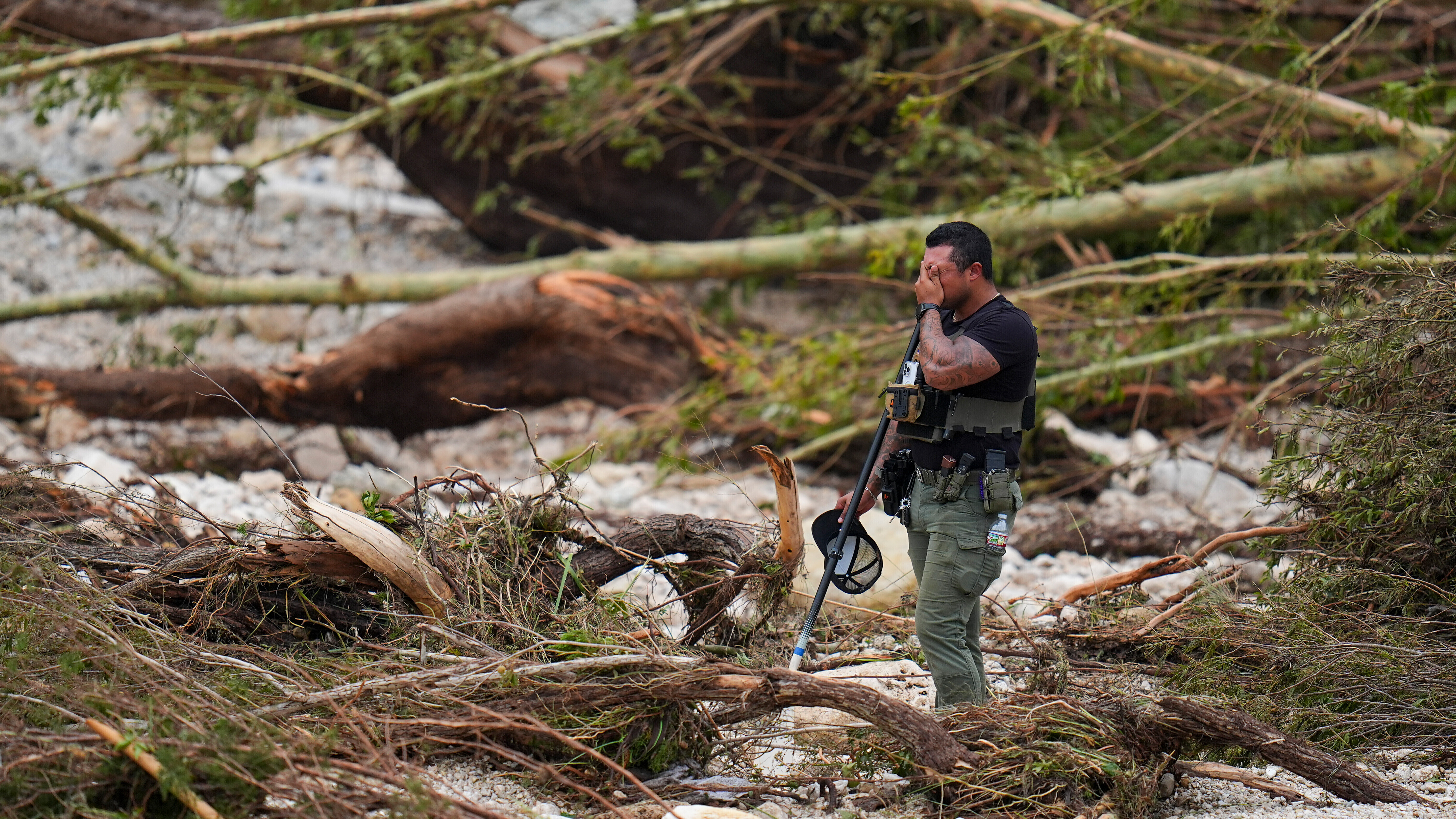 A sheriff's deputy pauses while combing through debris on the banks of the Guadalupe River near Camp Mystic in Hunt, Texas, on July 5, 2025, after a deadly flash flood swept through the area.