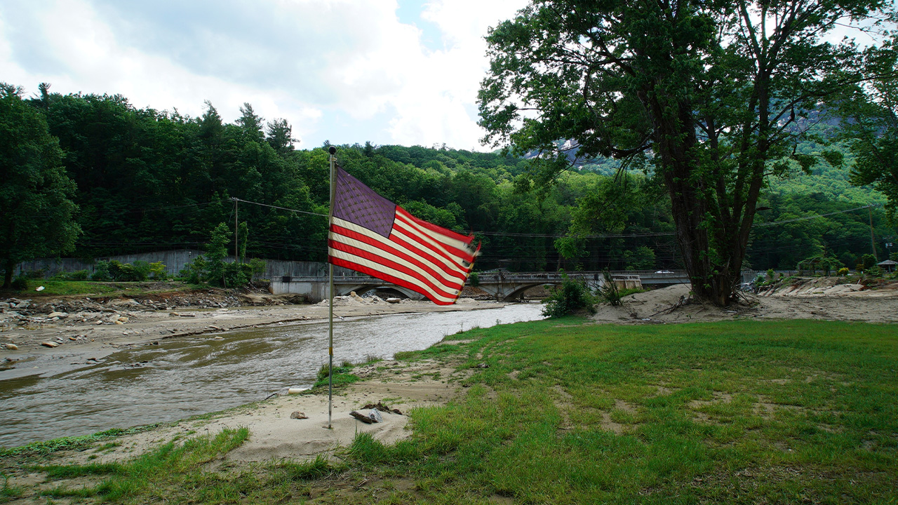 Martedì 13 maggio 2025, una bandiera squallida si trova nel letto di inondazione vicino all'intenso ponte di fioritura danneggiato sul lago NC.