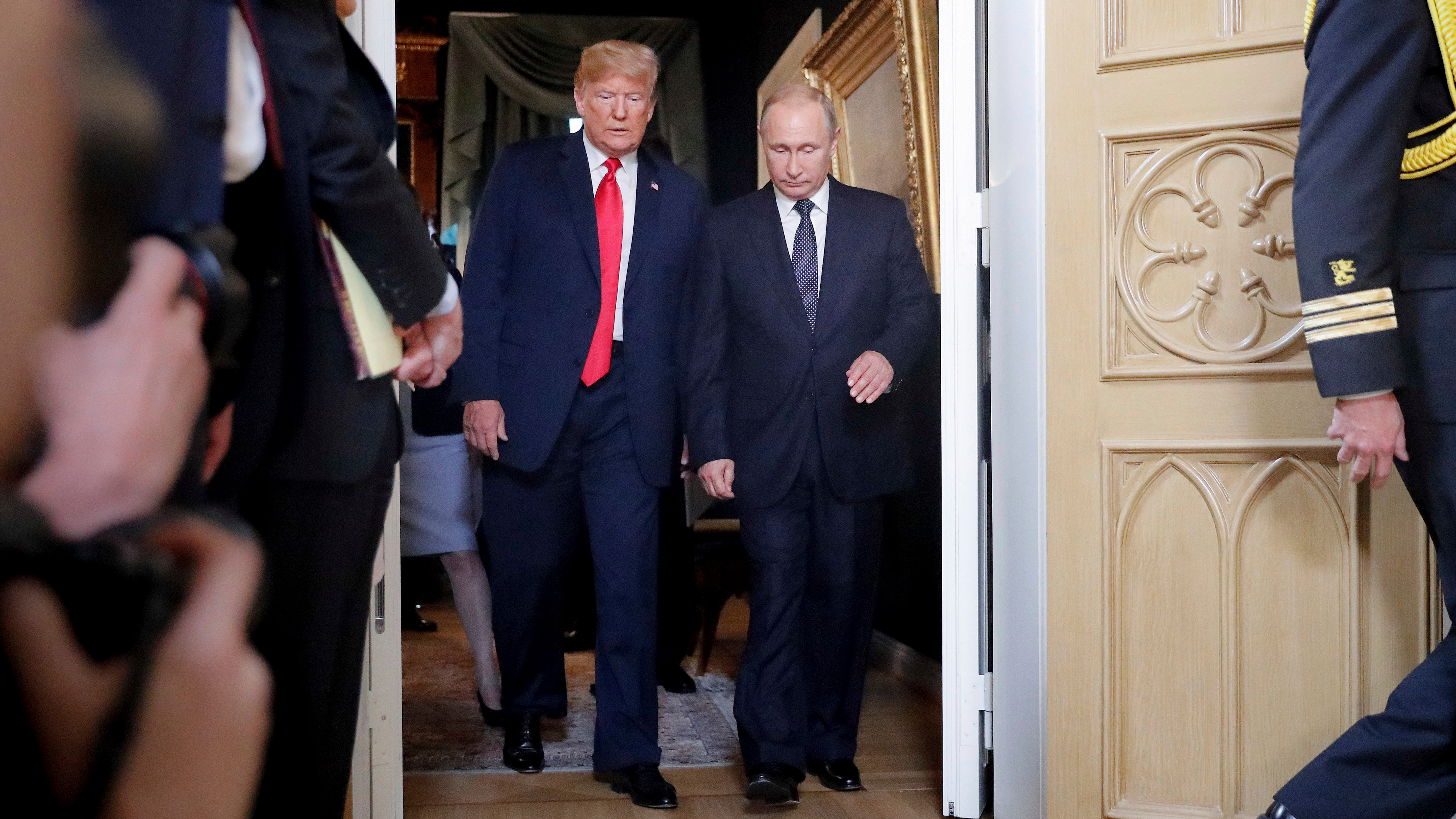 President Donald Trump, left, and Russian President Vladimir Putin, right, arrive for a one-on-one-meeting at the Presidential Palace in Helsinki, Finland, July 16, 2018.