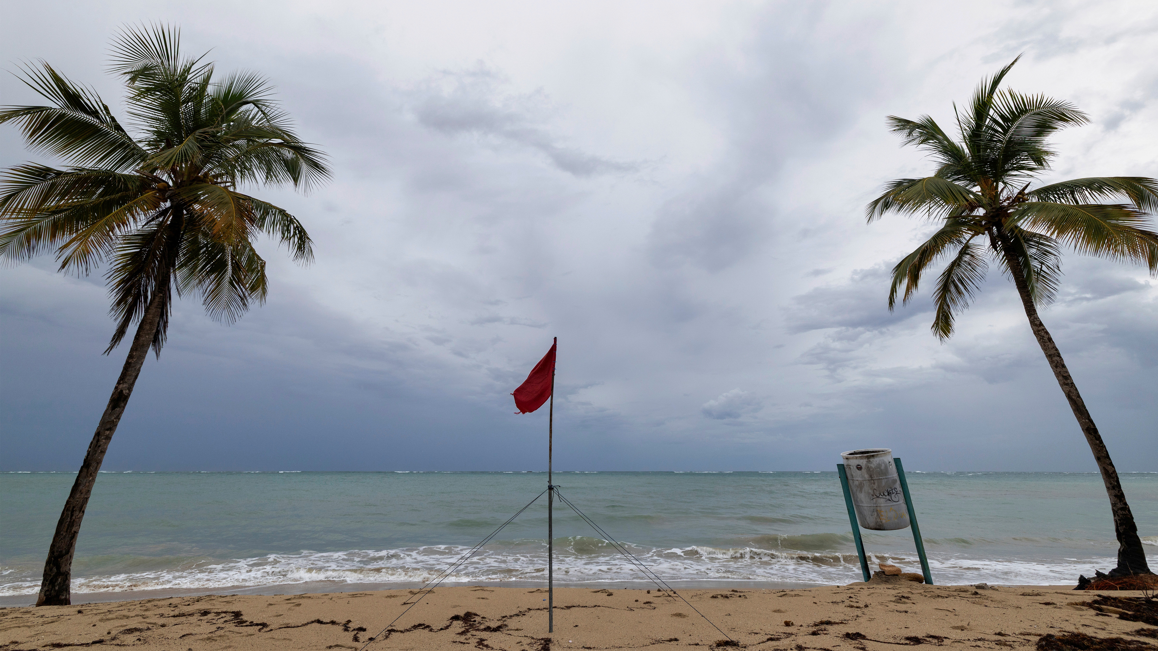 A red flag warns of dangerous waves on an empty beach in San Juan, Puerto Rico, after Hurricane Erin passed by near the island on Sunday, Aug. 17, 2025.