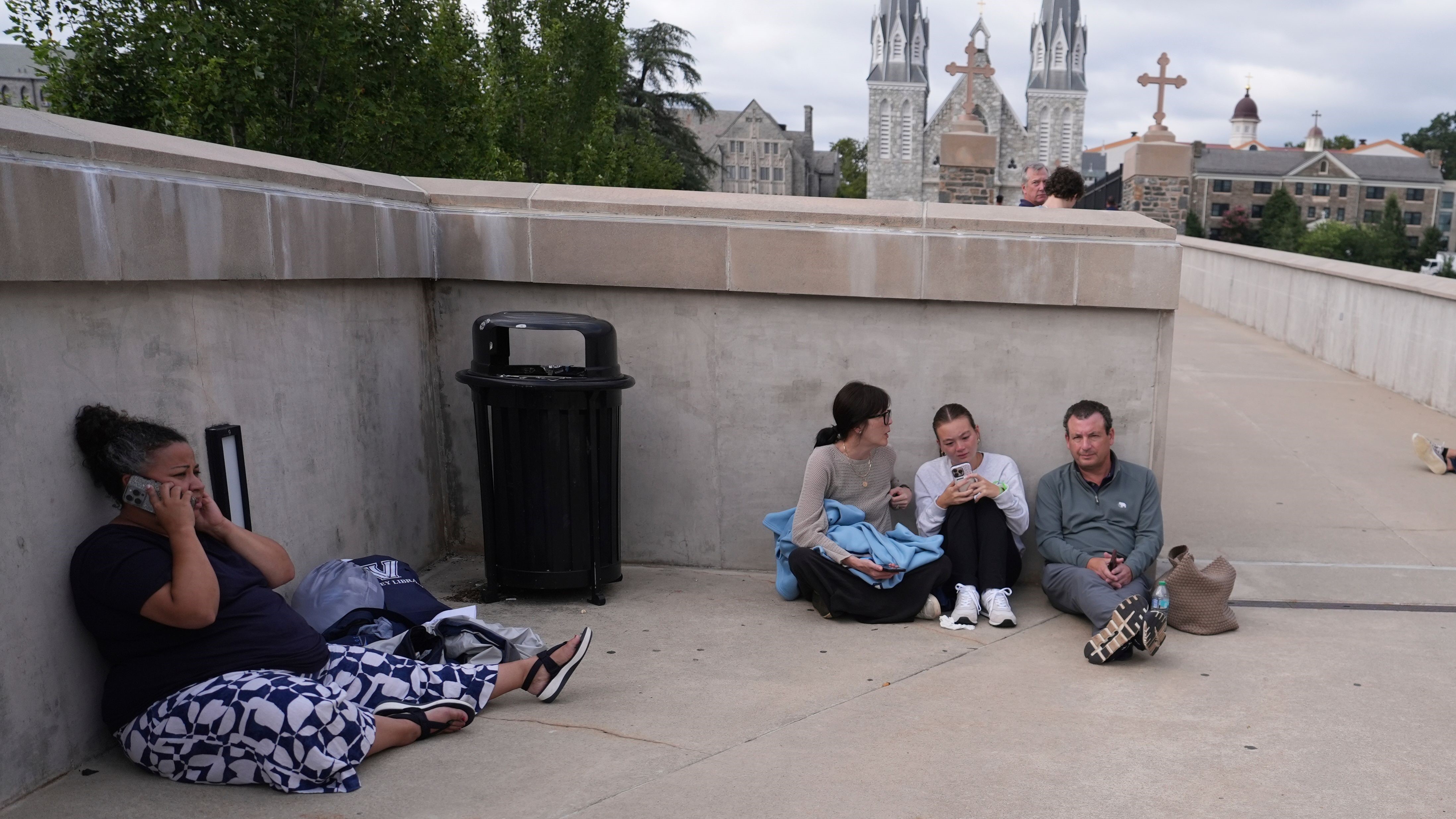 People shelter behind a wall at Villanova University on August 21.