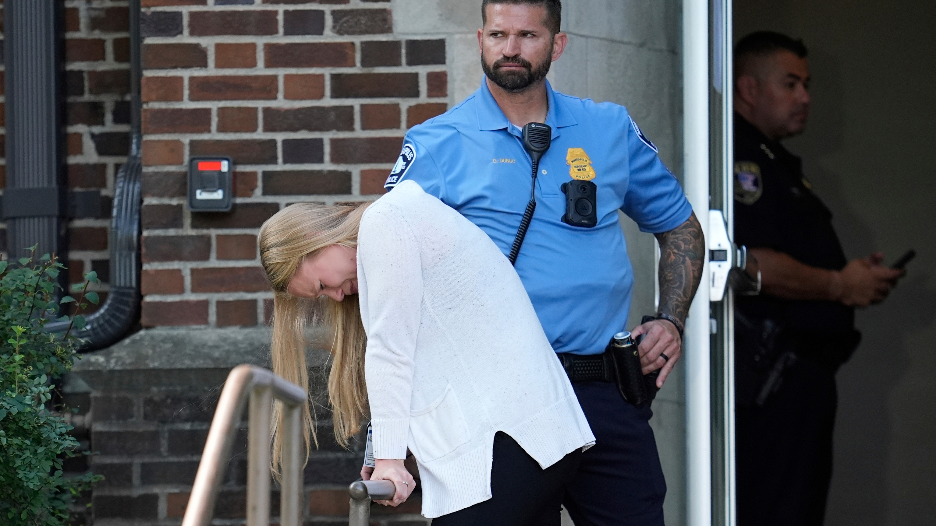A person walks out of the Annunciation Church's school as police respond to a reported mass shooting, Wednesday, Aug. 27, 2025, in Minneapolis.
