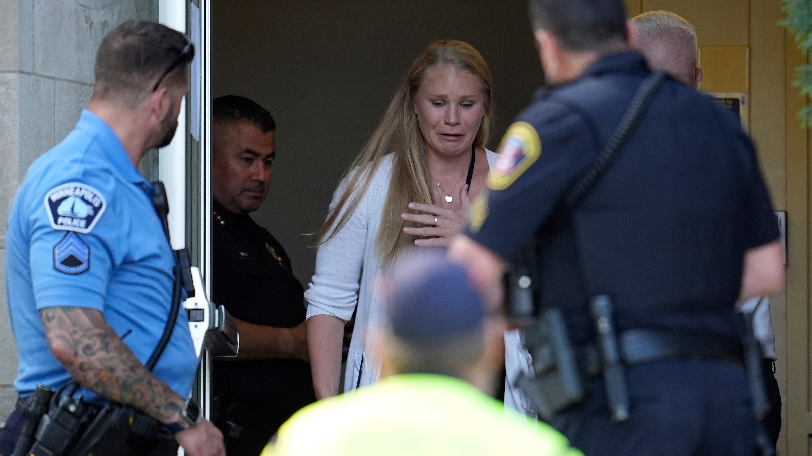 A person walks out of the Annunciation Church's school as police response to a reported mass shooting, Wednesday, Aug. 27, 2025, in Minneapolis.