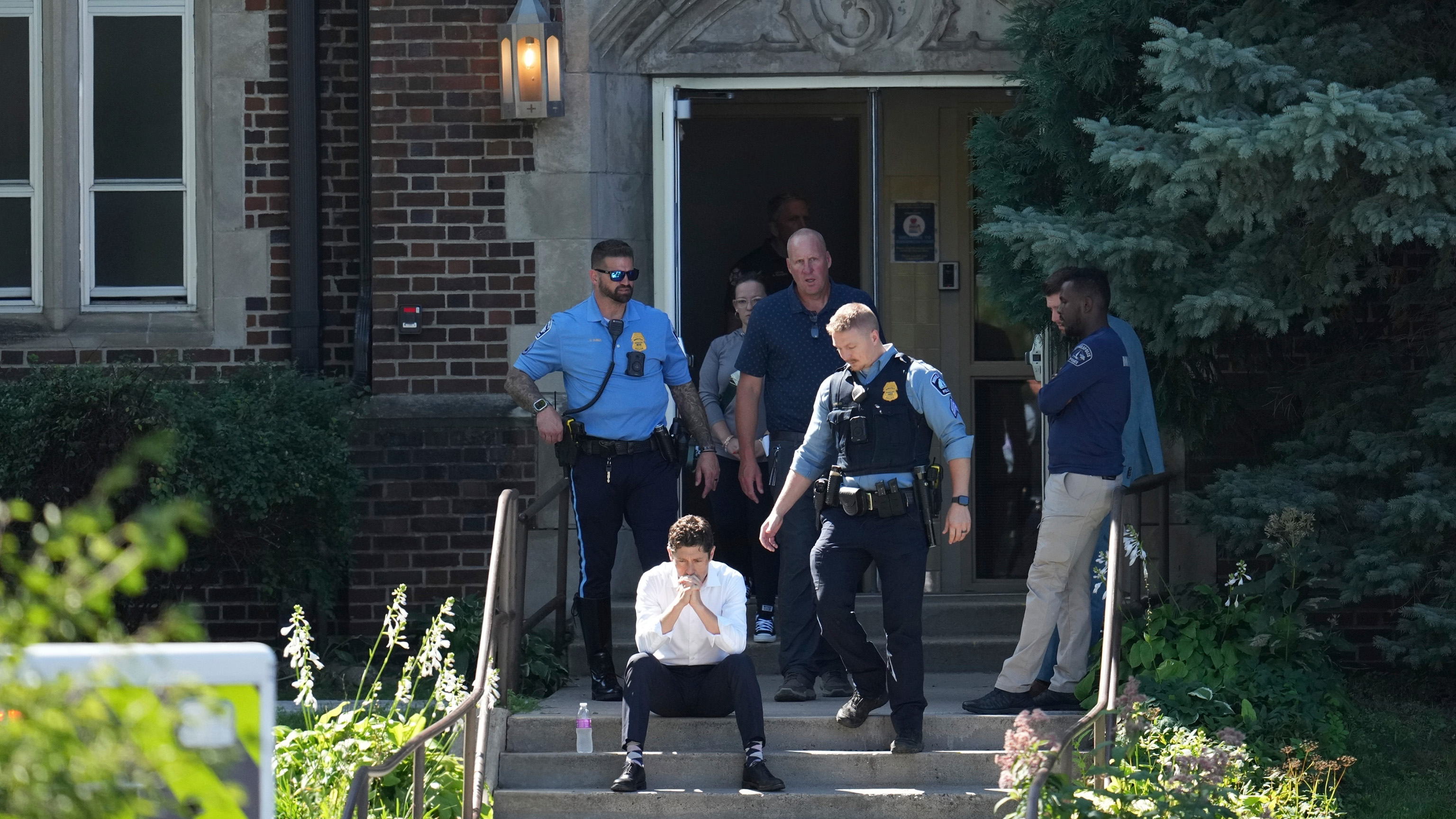 Minneapolis Mayor Jacob Frey sits on steps of the Annunciation Church's school as police response to a reported mass shooting, Wednesday, Aug. 27, 2025, in Minneapolis.
