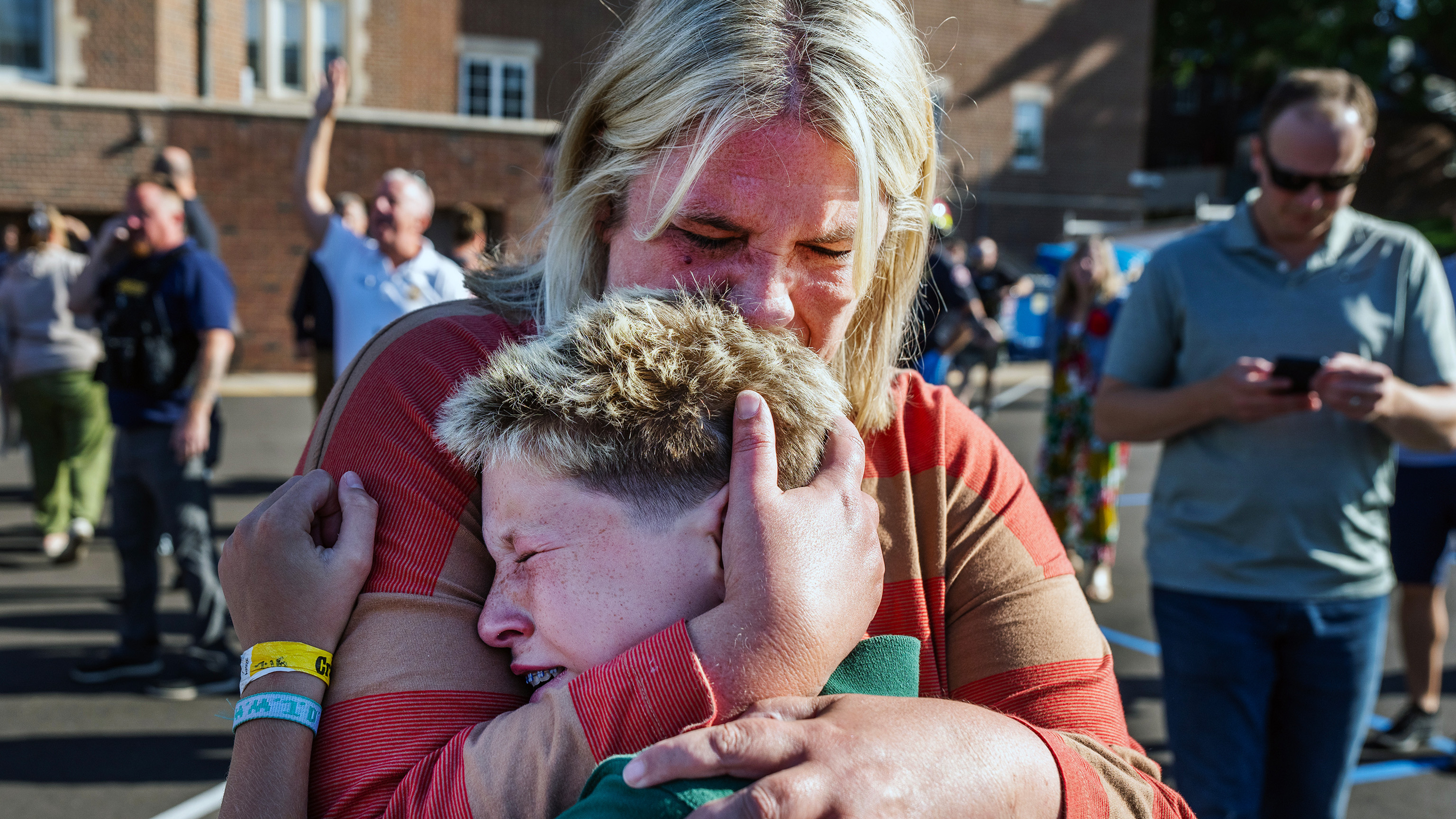 A parent hugs her son during an active shooter situation at the Annunciation Church in Minneapolis, Minn., Aug. 27, 2025.