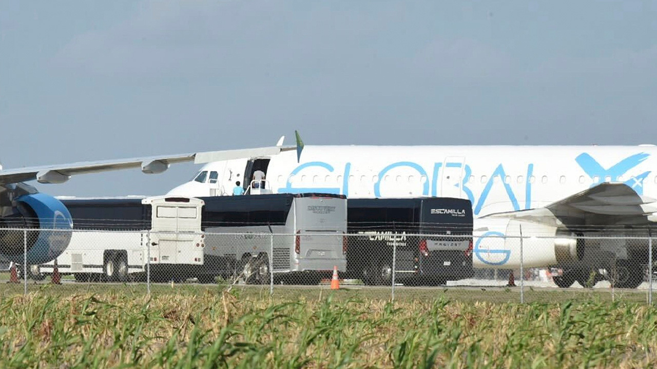 People board a plane in Harlingen, Texas Sunday, Aug. 31, 2025, as four charter buses are pulled into the side of the airport to unload dozens of passengers.