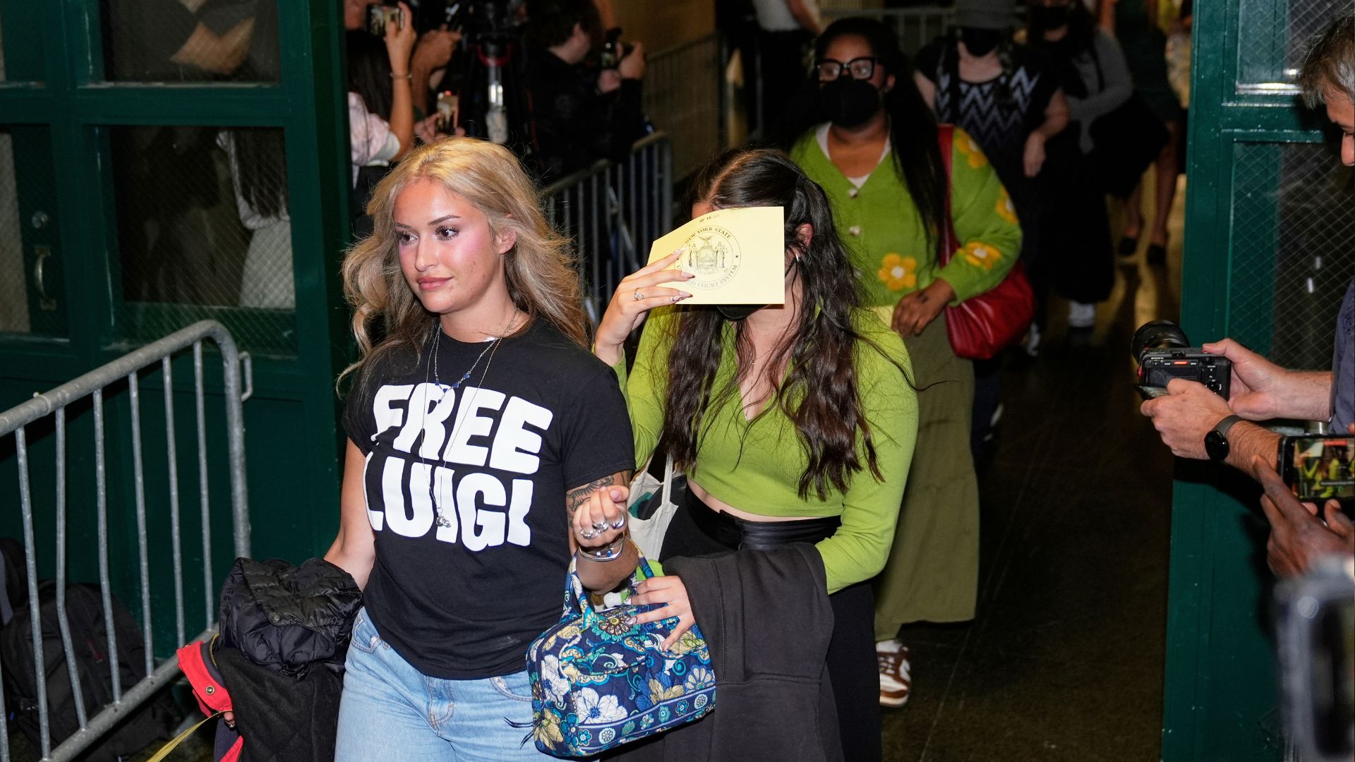 Members of the public, including a woman wearing a "Free Luigi" shirt, enter a courtroom before Luigi Mangione is escorted into the courtroom in New York, Tuesday, Sept. 16, 2025.