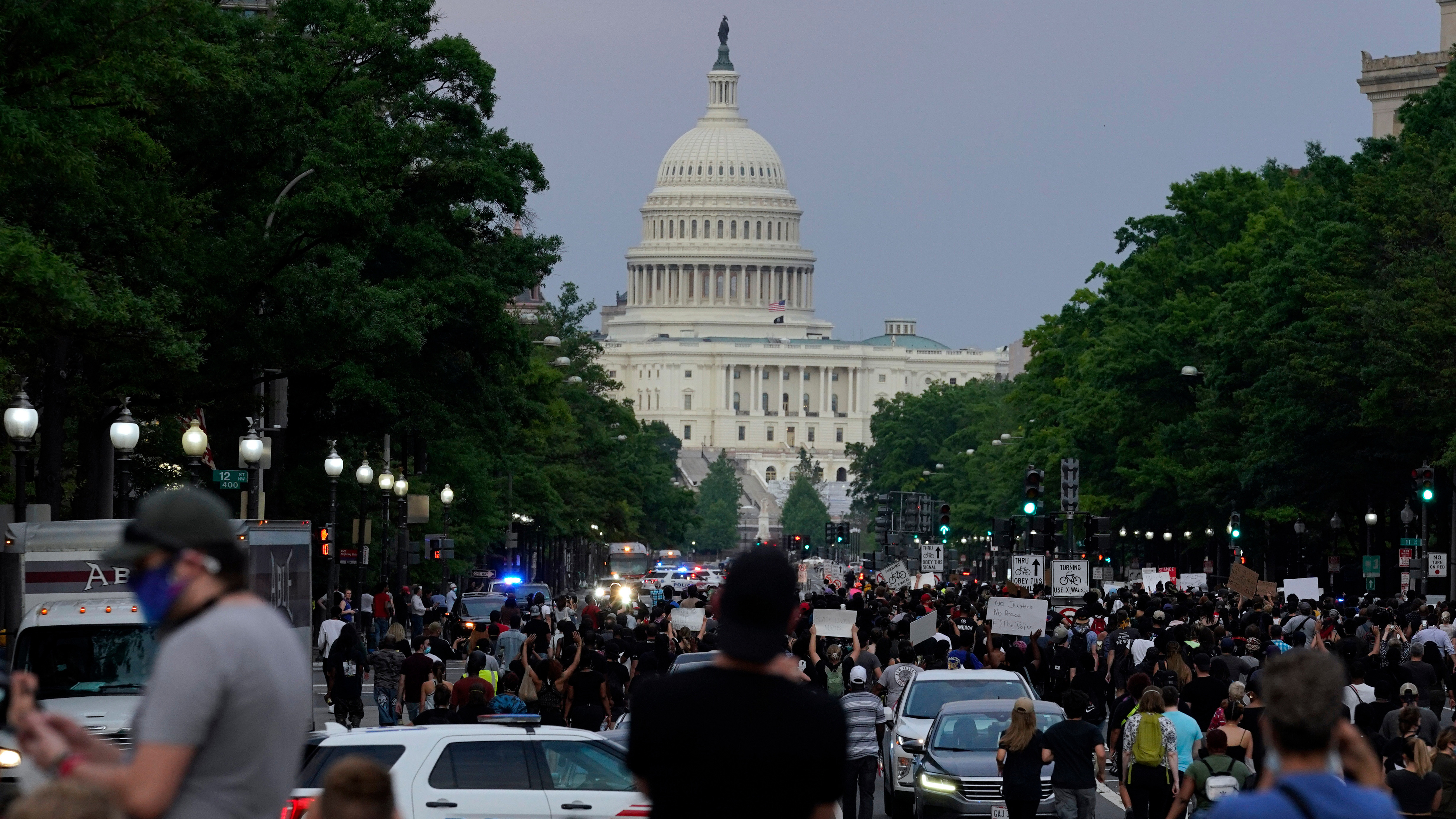 Demonstrators walk along Pennsylvania Avenue as they protest the death of George Floyd, May 29, 2020, in Washington.