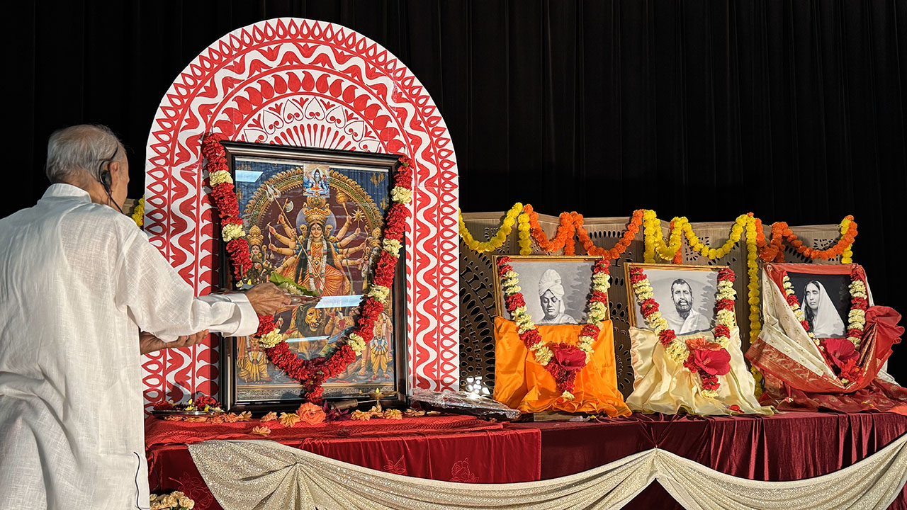 Il reverendo Shri Pruvin Shukla Ji guida il sacro culto di Durga durante la celebrazione della West Cary Middle School e offre fiori in preghiera