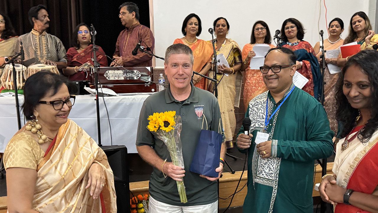 Morrisville Mayor TJ Cawley is welcomed with flowers before addressing the gathering.